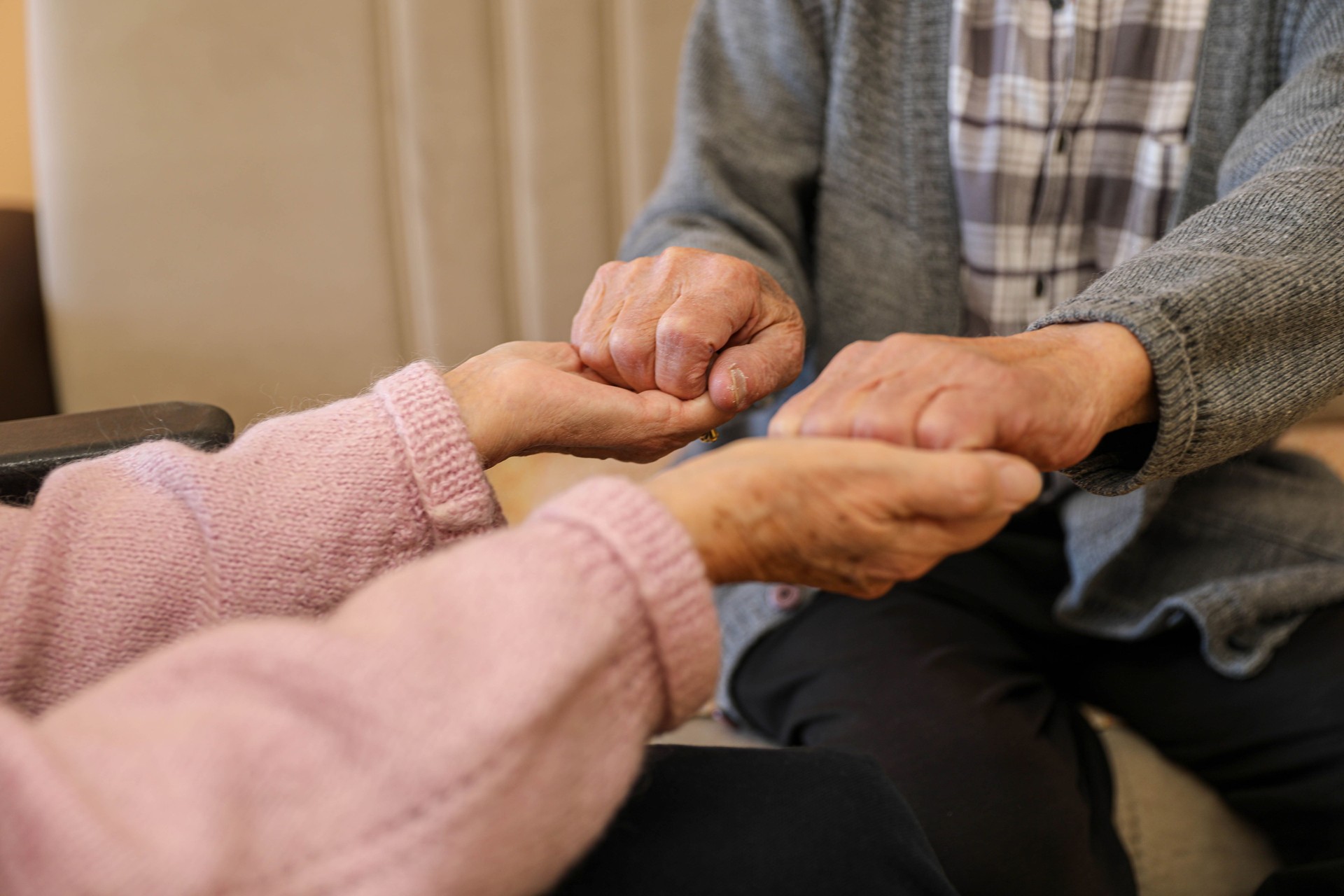 Compassionate Care: A Caregiver Holding an Elderly Woman’s Hands